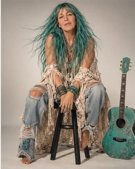 Aria Lightness seated beside her turquoise guitar